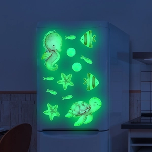 Luminous green ocean animal wall stickers glowing on a fridge in a dark room
