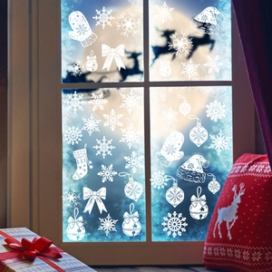 White snowflake and Christmas bell static window decals on a blue night window pane