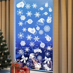 Detail of white Christmas window decals featuring snowflakes and bells on glass
