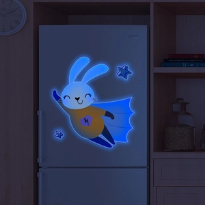 Luminous blue superman rabbit and stars wall decals glowing on a fridge in a dark room