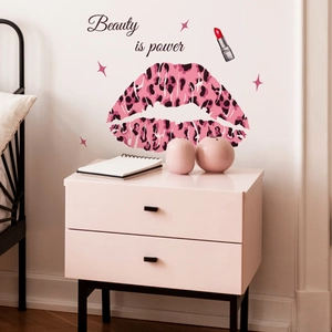 Detail of pink leopard print lips and 'Beauty is power' wall sticker in a bedroom