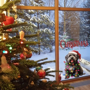 Christmas window cling featuring a cute dog with holiday lights on snowy glass