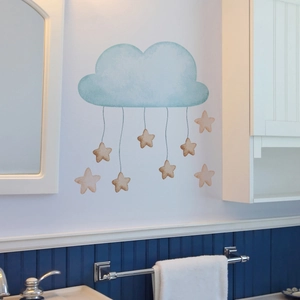 Detail showing blue watercolor cloud wall decal with hanging stars in a bathroom