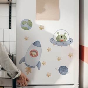 Close-up of space exploration cartoon stickers featuring bears and UFOs on a fridge