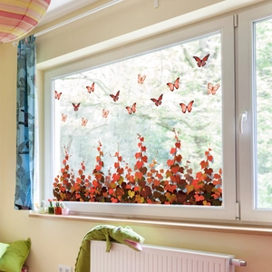 Close-up of autumn orange butterfly and leaf window stickers on a glass window