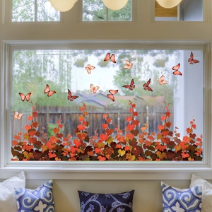 Detail of autumn window decals featuring red ivy vines and orange butterflies in sunlight