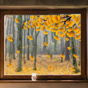 Close-up of bright yellow ginkgo leaf static window clings on glass with autumn forest view