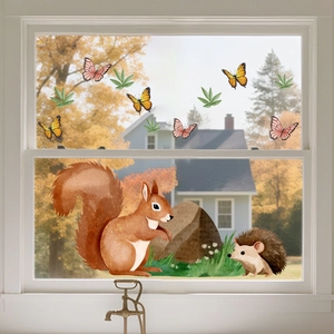 Close-up of squirrel and hedgehog static window decals on glass with autumn background