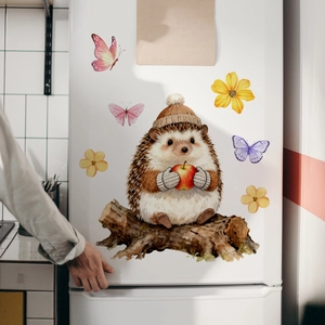 Close-up of watercolor hedgehog and butterfly stickers on a white refrigerator