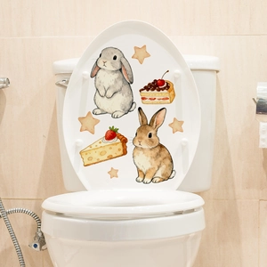 Detail of creative bunny and cake stickers on a white toilet lid for home bathroom decor