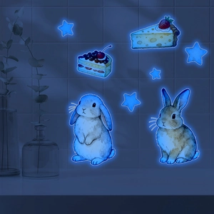 Luminous watercolor bunny and cake wall stickers glowing on dark blue tiled wall surface