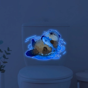 Luminous sea otter toilet sticker glowing in bright blue light within a dark bathroom