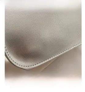 Detail of silver metallic leather texture and precise stitching on the shoulder bag