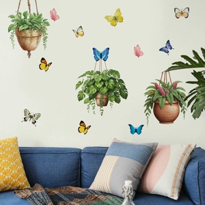 Detail of creative watercolor potted plants and colorful butterfly wall stickers over sofa