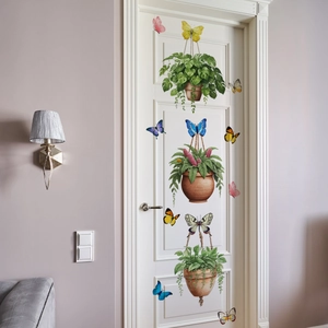 Detail view of cartoon potted plants and butterflies stickers on a white wooden door
