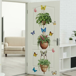 Detail of 3 hanging green potted plants and 9 colorful butterfly wall stickers on a door