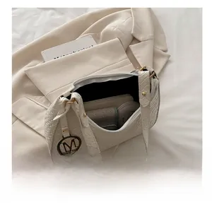 Internal capacity of cream woven underarm bag showing space for phone and makeup