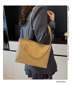 Détail d'un grand sac cabas jaune moutarde avec coutures verticales pour le bureau