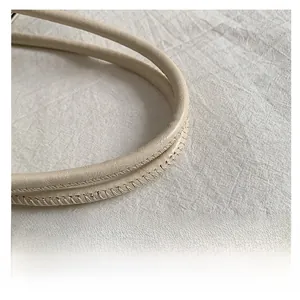 Détail de la poignée en similicuir crème avec surpiqûres sur un grand sac cabas