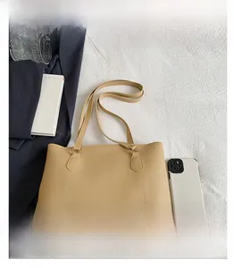 Détail des finitions du cabas beige et texture du similicuir sur un costume bleu foncé