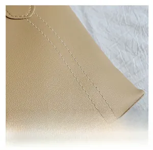 Gros plan des coutures renforcées et du grain lychee sur le sac à main fourre-tout kaki