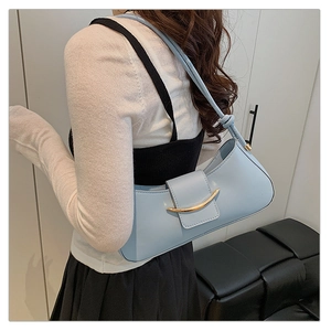 Close-up of light blue leather shoulder bag with gold buckle and knotted strap detail