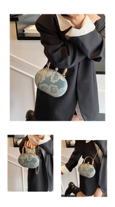 Detail view of heart-shaped handbag with golden floral embroidery and pearl clasp
