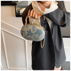 Detail of blue-grey evening clutch bag with gold floral embroidery and ring handle
