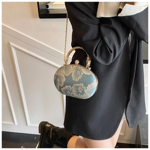 Detail of teal vintage evening bag with gold peony embroidery and metallic handle