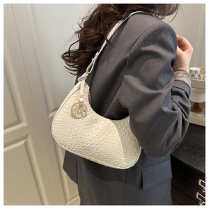 Detailed close-up of woven texture and metal M logo on cream white underarm bag for women