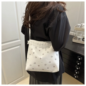 Détail du sac à bandoulière blanc avec bordure en dentelle et motifs d'animaux mignons