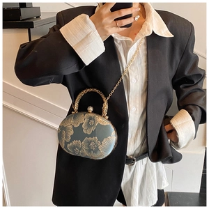 Detail of Chinese style bag with gold floral embroidery, pearl clasp and metal chain strap
