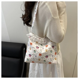 Détail du sac cabas pour femme avec motifs d'ours colorés et bordures en dentelle blanche