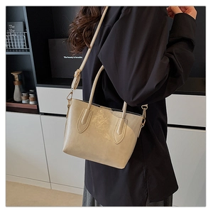 Détail du grand sac cabas beige montrant la bandoulière réglable et la texture du cuir