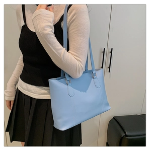 Gros plan sur un cabas en cuir bleu clair avec doubles anses et coutures verticales