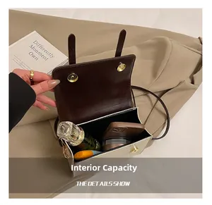 Interior view of the two-tone crossbody bag showing capacity for phone and perfume