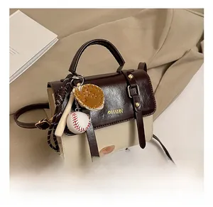 Close-up of contrast-color small square bag with baseball charms and fashion print