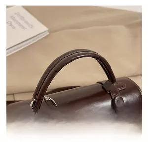 Detailed macro view of retro brown oil-wax leather handbag handle with gold metal rivets