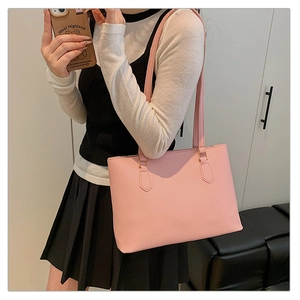 Détail du sac cabas rose clair avec coutures verticales et longues bandoulières