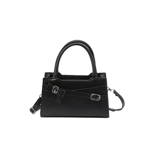 Classic black leather crossbody bag with cross-strap details and a bow tie accent
