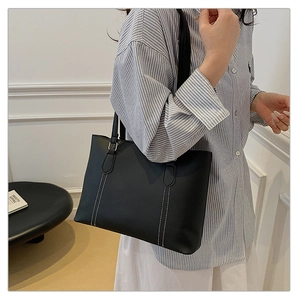 Vue détaillée du grand sac cabas en cuir noir avec élégantes surpiqûres blanches contrastées