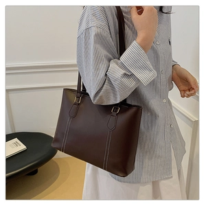 Vue détaillée du sac cabas marron foncé avec d'élégantes surpiqûres doubles blanches