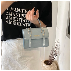 Detalle del bolso bandolera azul claro en cuero PU con herrajes dorados de moda