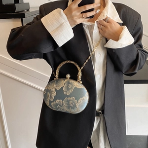Blue floral embroidery evening bag with gold handle and chain shown on model