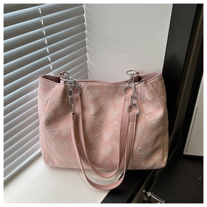 Detailed shot of pink tote bag with white 3D heart embroidery and silver chain link strap