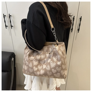 Detail of canvas tote bag with white heart embroidery and leather chain strap
