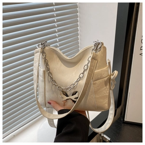 Detail of creamy white shoulder bag with silver butterfly buckle and metal chain strap