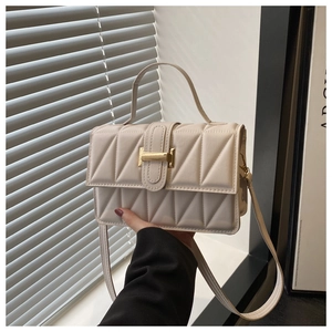 Vue détaillée d'un sac à bandoulière en cuir matelassé beige avec boucle en métal doré