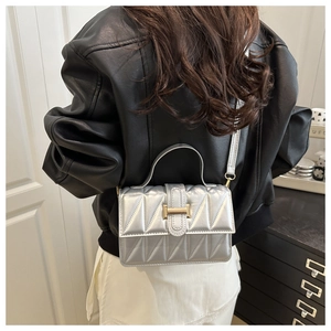 Petit sac à bandoulière argenté matelassé avec texture géométrique sur modèle