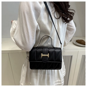 Vue arrière d'un sac bandoulière matelassé noir avec détails dorés porté par un mannequin